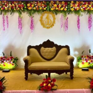 Home This image features an elegant wedding stage decorated with colorful fresh flowers, soft lighting, and a classy white backdrop 🌸✨ The royal sofa seating and floral arrangements create a perfect and luxurious setup for the bride and groom, ideal for photography and memorable moments